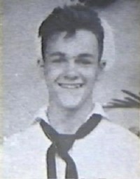 black and white portait of smiling young man in white Navy uniform.
