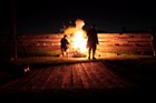 A dark night. A fort embrasure is lit up by an exploding cannon. A fireball flies from the muzzle.