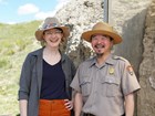 two people standing next to a rock outcrop