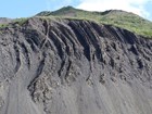 hillside bluff with rock layers in overturned beds exposed