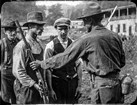 Three miners in hats and rough clothing hand over rifles to uniformed federal troops. 