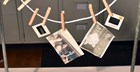 Several wet photographs clipped to a clotheslines using clothespin to allow the photographs to dry