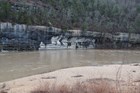 Murky floodwaters surge at the base of Painted Bluff