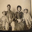 An African American soldier in Union Army uniform sits with his family for a photograph.