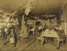 Enlisted men sitting inside a room decorated for Christmas.