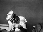 Man in white sailor hat and shirt threading a needle