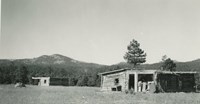 two log buildings in the mountains
