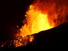 volcanic eruption with glowing lava seen at night
