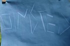 Close up view of word Olmsted sunprinted on blue paper