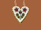 White beaded bag in heart shape. Two flowers and two stars. Orange background.