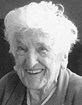 Black and white photo of a smiling older woman with white hair.