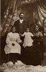 Well-to-do Black family of 5 pose for professional photo wearing fine Victorian clothing
