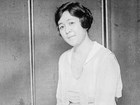 Japanese woman in flouncy white dress and coiffed hair sits for studio portrait