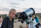 A child looking through a telescope.