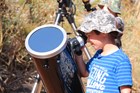 A child looking through a telescope.