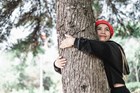 A woman hugging a tree.
