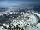 photo of oblique aerial view of a volcanic caldera with snow and ice