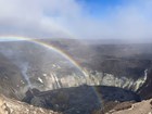 photo of a volcanic calders with clouds and a rainbow