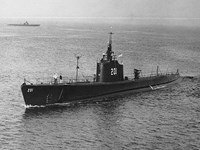 black and white photo of large submarine with number 203 painted on it on top of the open water.