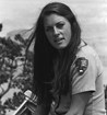 Eileen Szychowski in NPS uniform, with crutches, sits on a wall with the Grand Canyon beyond.