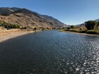 A dark blue flowing river lined by hills and mountains.
