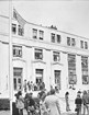 A group of people stands in front of building