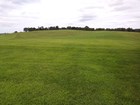 A broad mowed hillside lawn preserves a battlefield. 