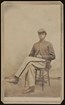 An unidentified African American soldier sits with a leg crossed over the other for his portrait.