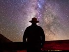 NPS ranger silhouetted against starry night sky.