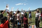 A park ranger conducts an outdoor activity with a group of children.