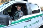 A park ranger smiles at us from his patrol vehicle.