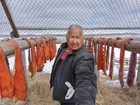 A man take a selfie while standing in front of a fish rack. 