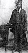 Historical image of a man standing in a suit.
