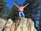 a person standing atop a fossil tree stump