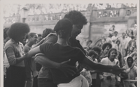 Two dancers dancing in front of a crowd. Black and white photo.