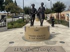 Statue of a young boy and girl walking with books in their hands.