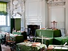 Empty antique chairs positioned around tables in the Assembly Room of Independence Hall. 