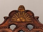 Close-up of detailed wood carving of a half sun on the top back of a chair. 