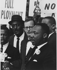 martin luther king with people and protest signs behind him