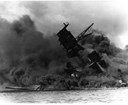 Black and white photo of the wreckage of the USS Arizona protruding from the water of Pearl Harbor