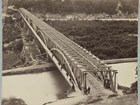 Sepia photo of Chain Bridge - early 1860s. Long metal bridge over 2 lengths of water and land patch.