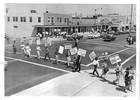 Black and white overhead photo of protestors, white and African American, crossing a street