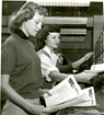 black and white picture of two white women sorting papers