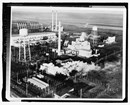 Black and white overhead of a factory complex and water tower in a forrest 