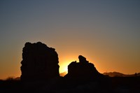 The blue and orange sunset behind the silhouette of unique ruins.