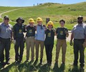 MCC Youth Crew members pose for a photo in front of a grassy area known as Buck Hill Trail project.