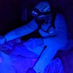 A volunteer using a black light to find lint on cave formations.