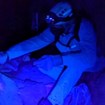 A volunteer using a black light to find lint on cave formations.