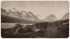 Historic photograph of a homestead and oil well with mountains in the background.