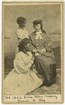 Ellen Murray sits in a chair with a book next to two students.